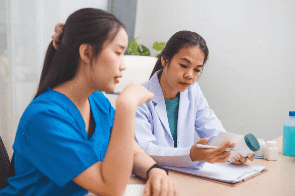 A doctor and a nurse are dedicatedly discussing adjustments to their patients' treatment protocols.