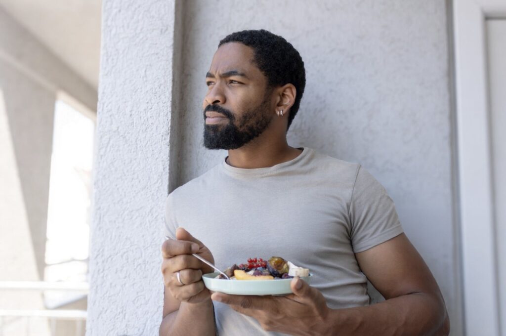 A man practices mindful eating habits by eating at a slower pace.